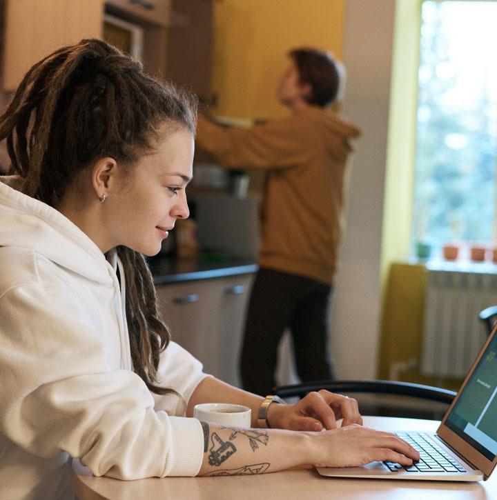 Young woman using a laptop in the kitchen at home