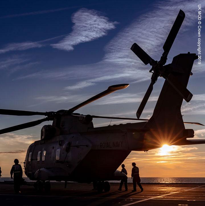 AW101 Merlin on aircraft carrier deck at sunset