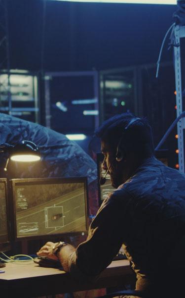 Military personnel work in bunker on screens