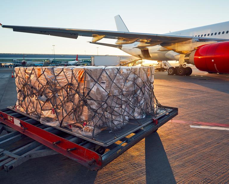 A large package is ready for loading onto airplane on tarmac