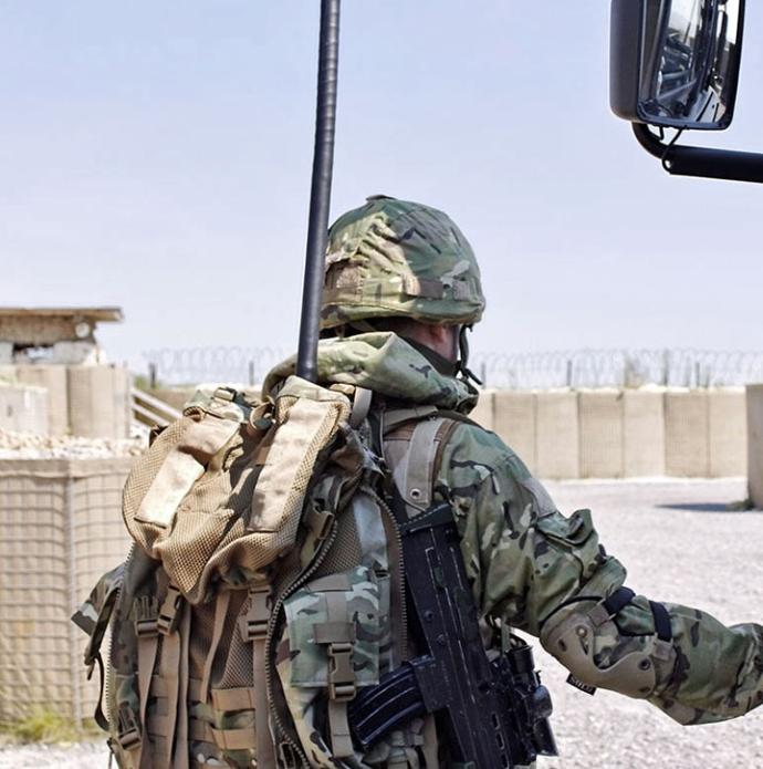 Soldier in a desert forward operating base with electronic warfare backpack