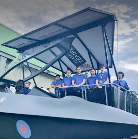 Group of young Leonardo STEM ambassadors standing beside the Tempest aircraft concept model