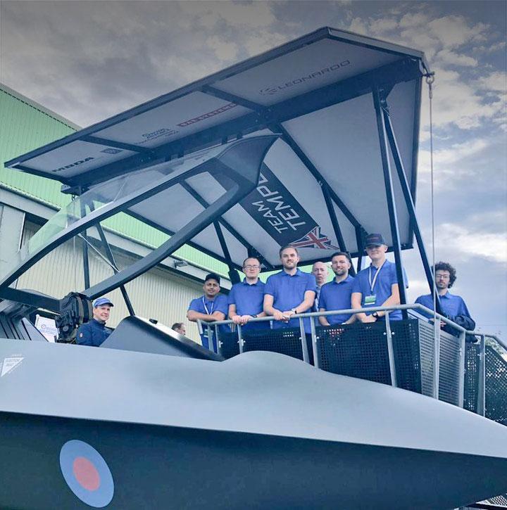 Team Tempest STEM ambassadors on steps by the aircraft concept model on display at air show